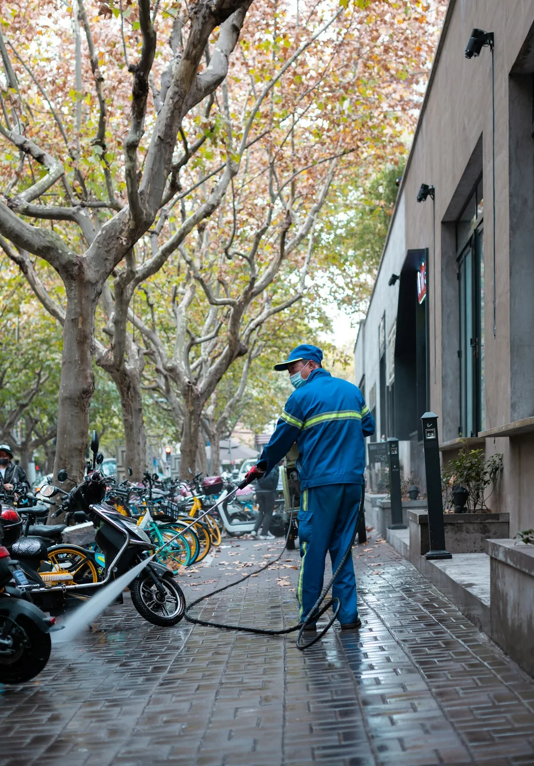 A man secured in a harness cleaning high-rise windows with careful precision.